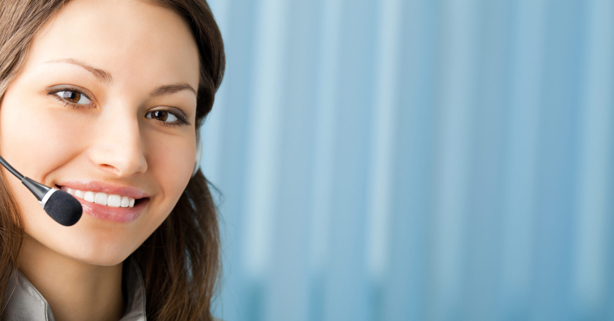 Young cheerful smiling support phone female operator in headset at office, with copyspace. To provide maximum quality, I have made this image, by combination of two photos.